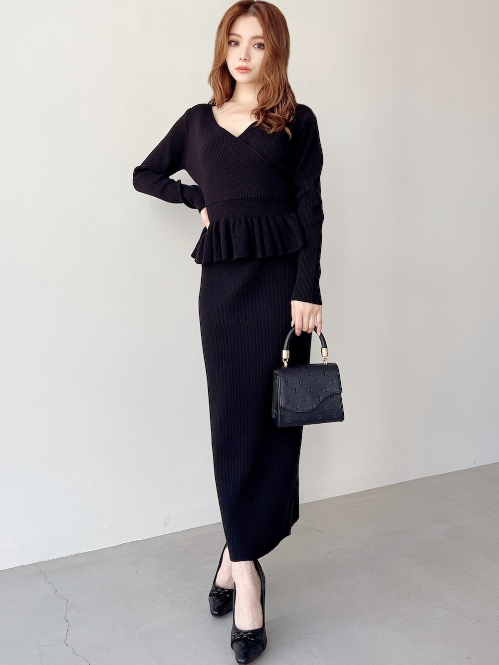 ブラック系のスカート、ブラック系のニット/セーター、ブラック系のパンプスを着用したレディースの秋コーディネートの2枚目の写真