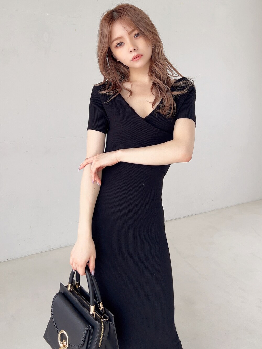 ブラック系のワンピース、ブラック系のパンプスを着用したレディースの春コーディネートの2枚目の写真