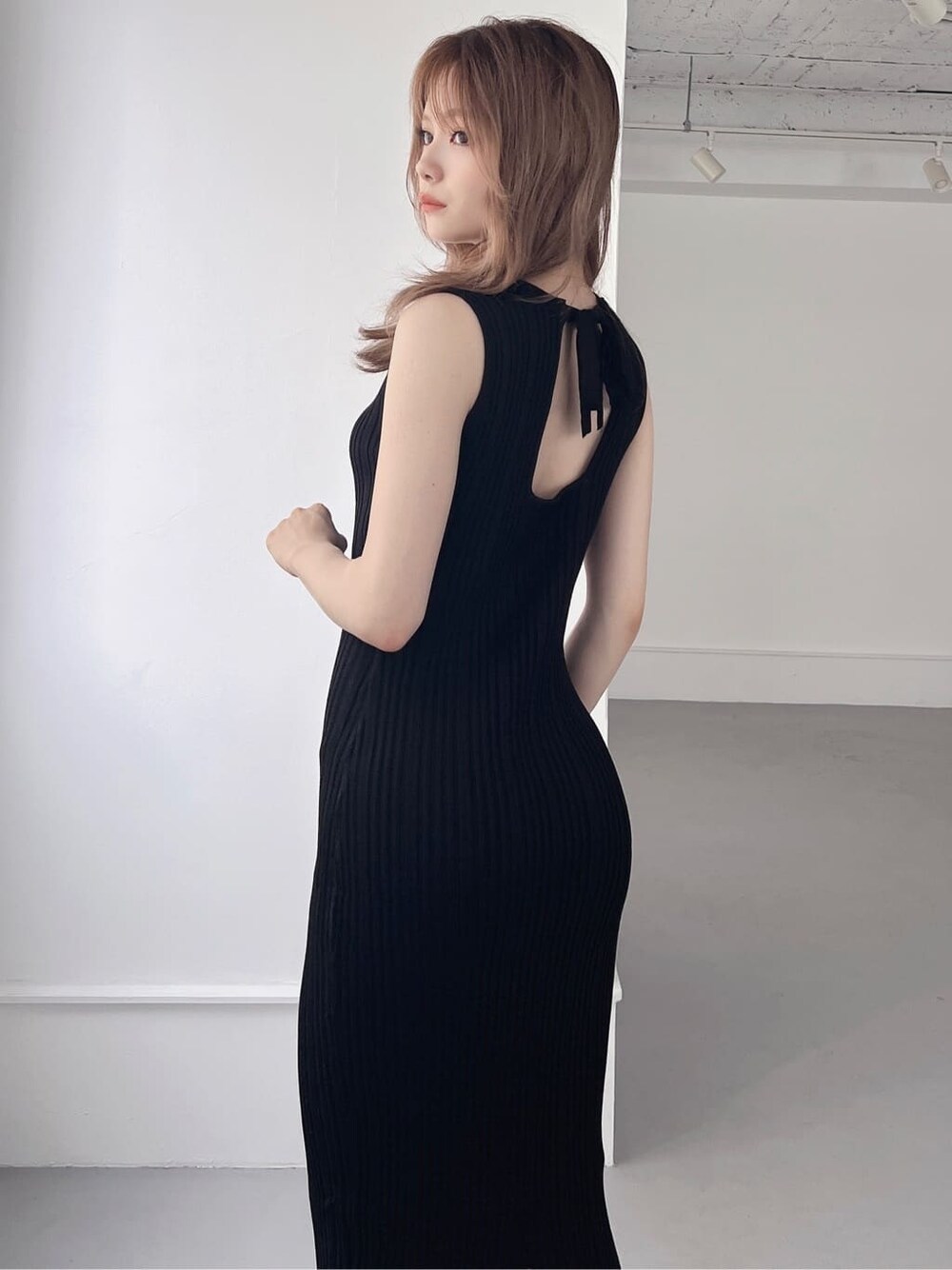 ブラック系のワンピース、ベージュ系のサンダルを着用したレディースの夏コーディネートの3枚目の写真