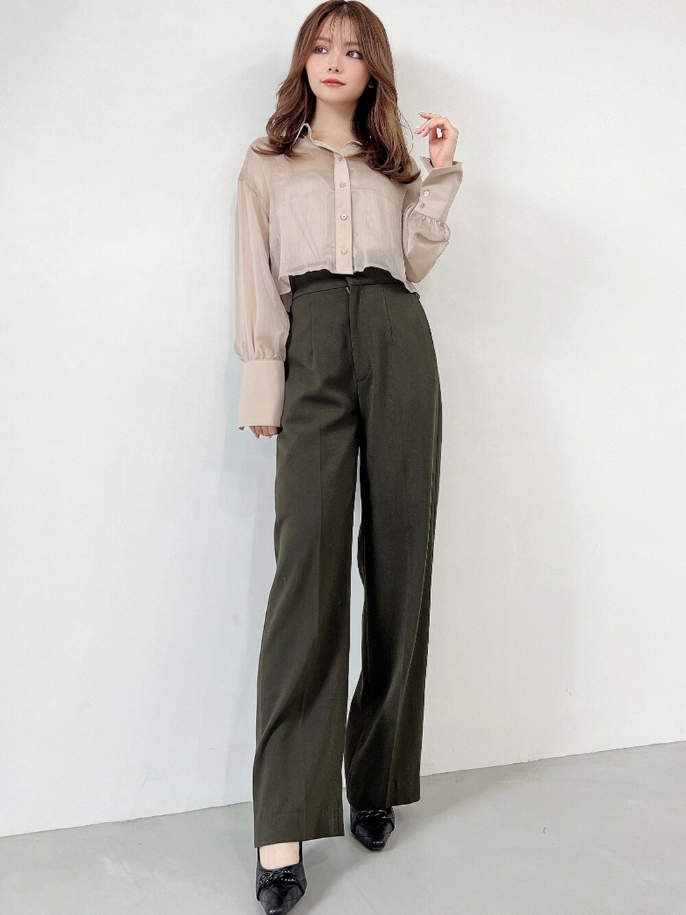 ベージュ系のシャツ/ブラウス、グリーン系のその他パンツ、ブラック系のパンプスを着用したレディースの秋コーディネートの2枚目の写真