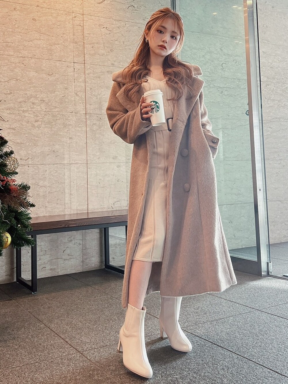 ホワイト系のブーツ、ベージュ系のその他アウター、ベージュ系のワンピースを着用したレディースの冬コーディネートの4枚目の写真