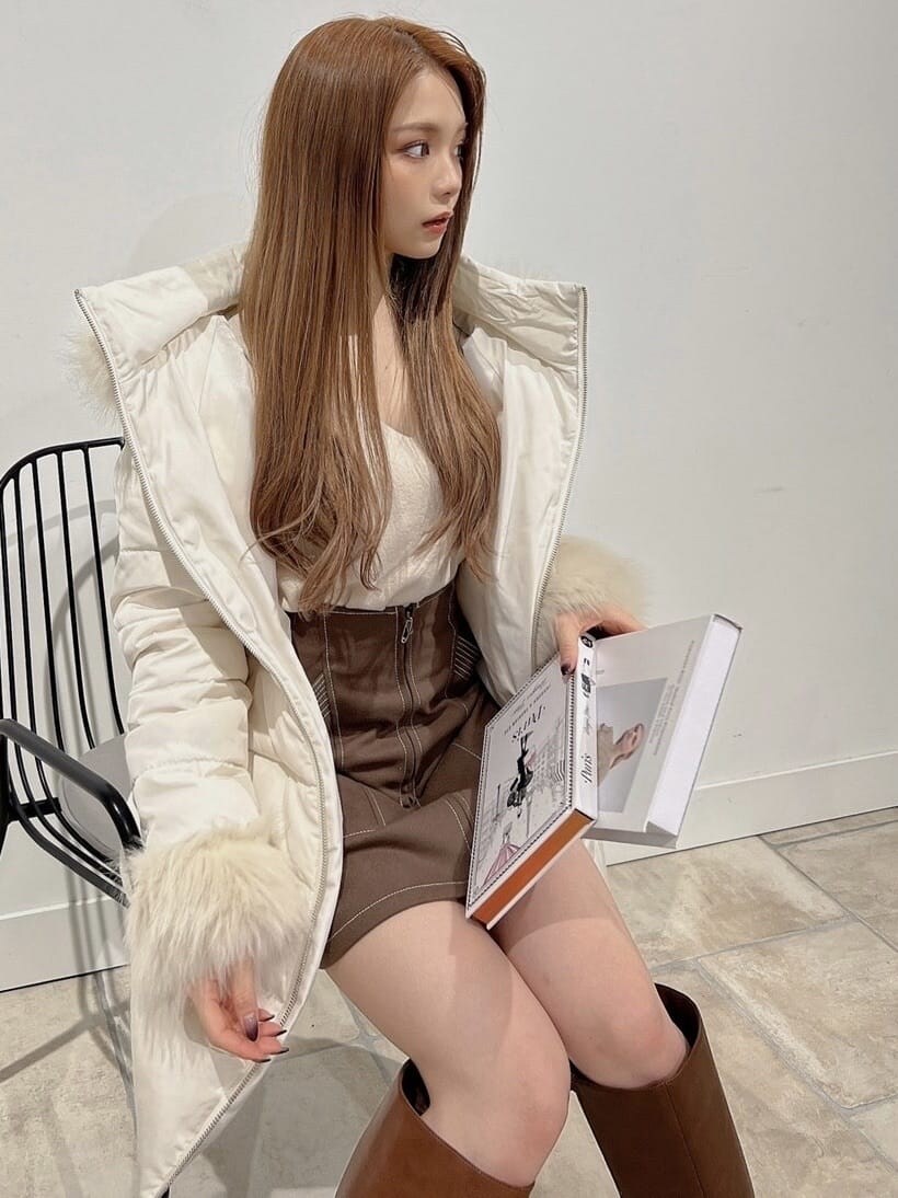 ベージュ系のニット/セーター、ホワイト系のダウンジャケット/コート、ブラウン系のブーツを着用したレディースの秋コーディネートの5枚目の写真