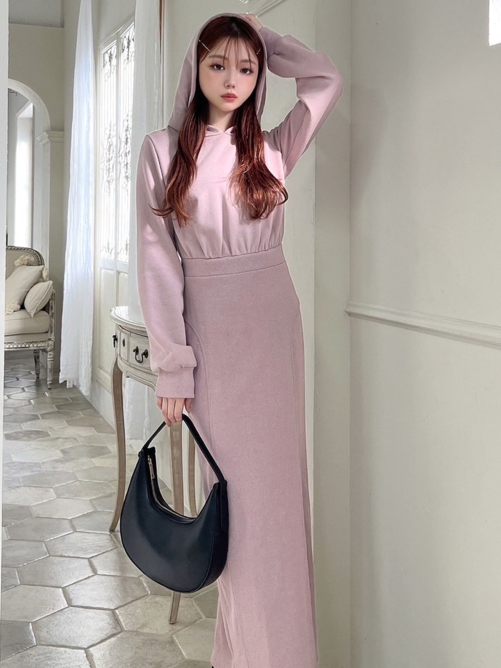 ピンク系のワンピース、ブラック系のハンドバッグ、ブラック系のブーツを着用したレディースの冬コーディネートの5枚目の写真