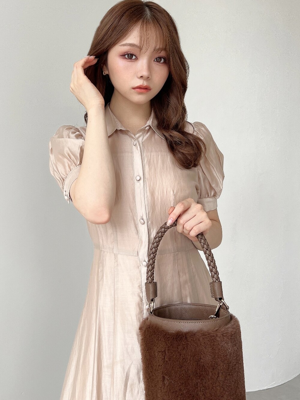 ベージュ系のワンピース、ブラウン系のショルダーバッグ、ブラウン系のブーツを着用したレディースの夏コーディネートの3枚目の写真