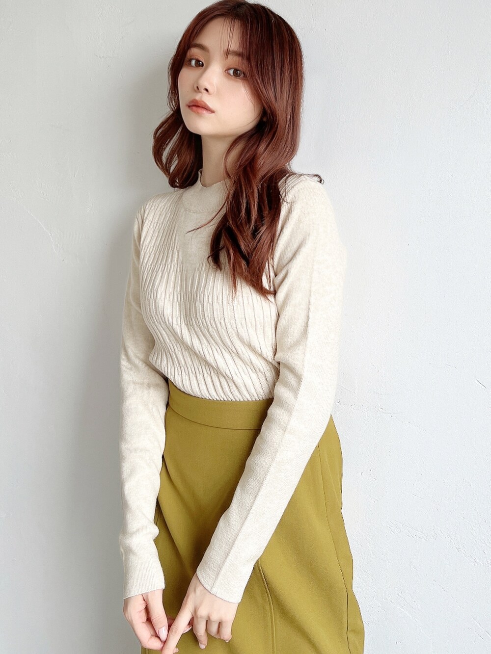 ブラウン系のスカート、ホワイト系のニット/セーター、ブラック系のチェスターコートを着用したレディースの冬コーディネートの5枚目の写真