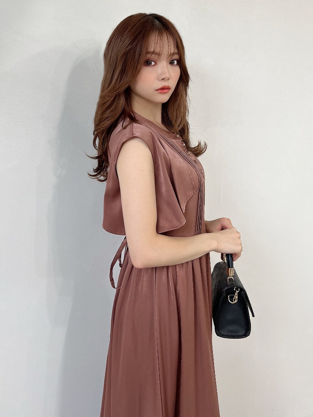 ブラウン系のドレス、ブラック系のパンプスを着用したレディースの秋コーディネートの3枚目の写真