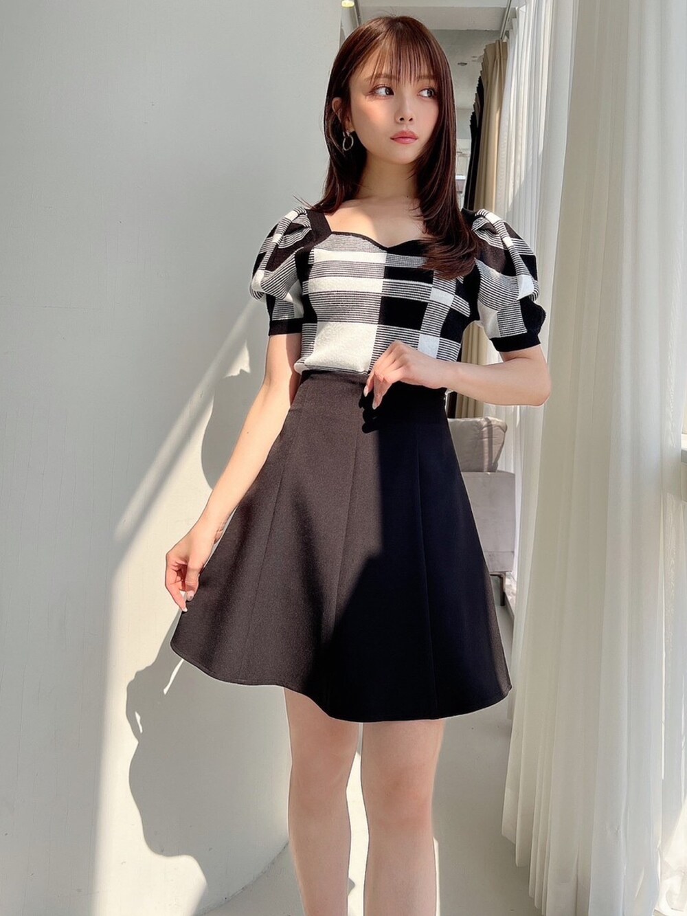 その他のニット/セーター、ブラック系のスカート、ゴールド系のピアス（両耳用）を着用したレディースの夏コーディネートの2枚目の写真