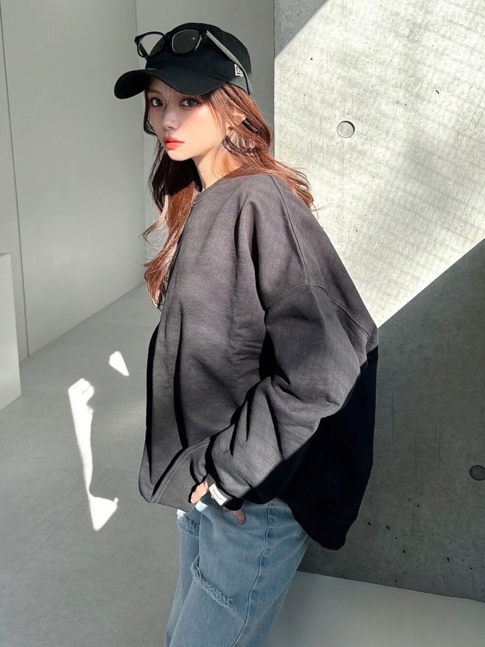 ブラック系のスウェット、ブルー系のデニムパンツを着用したレディースの春コーディネートの7枚目の写真