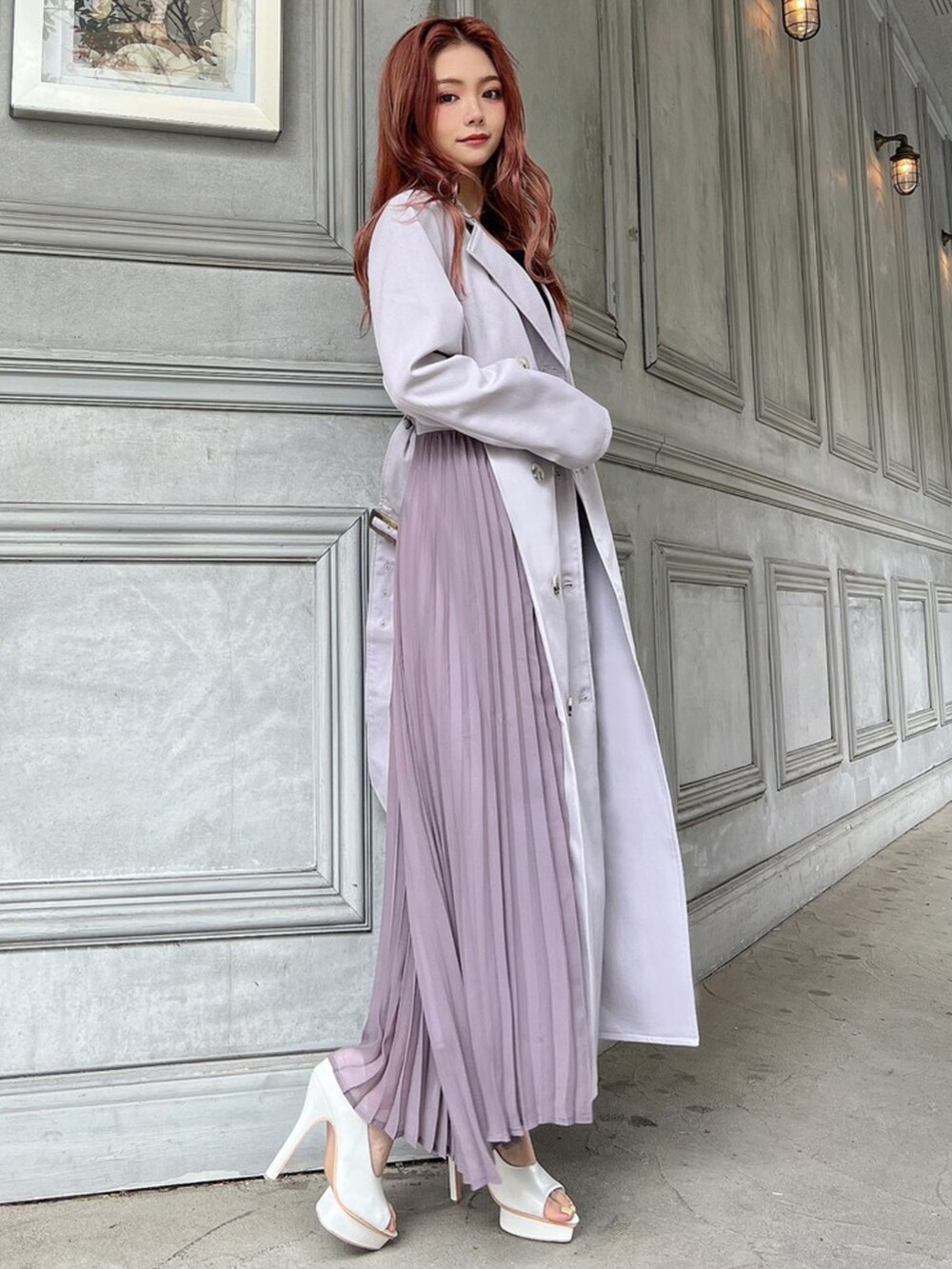 パープル系のトレンチコート、ブラック系のワンピース、ホワイト系のパンプスを着用したレディースの春コーディネートの3枚目の写真