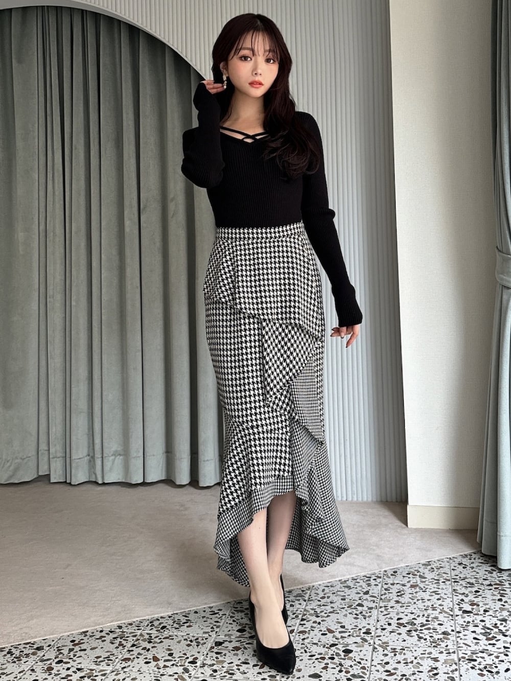 ブラック系のニット/セーター、その他のスカート、ブラック系のパンプスを着用したレディースの冬コーディネートの2枚目の写真