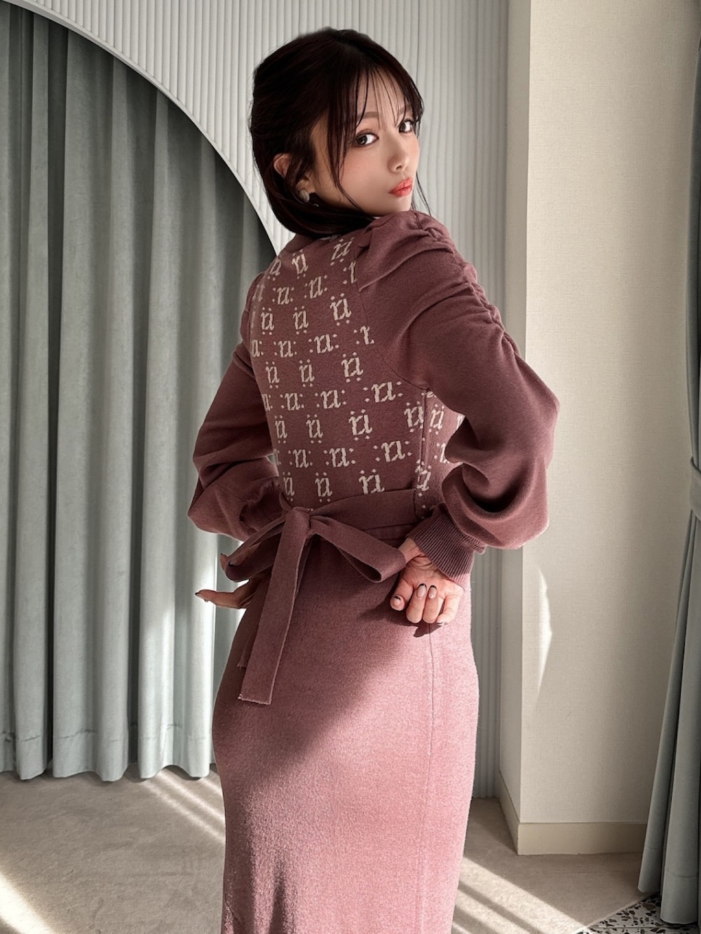 ブラウン系のワンピース、ホワイト系のパンプス、ホワイト系のハンドバッグを着用したレディースの冬コーディネートの4枚目の写真