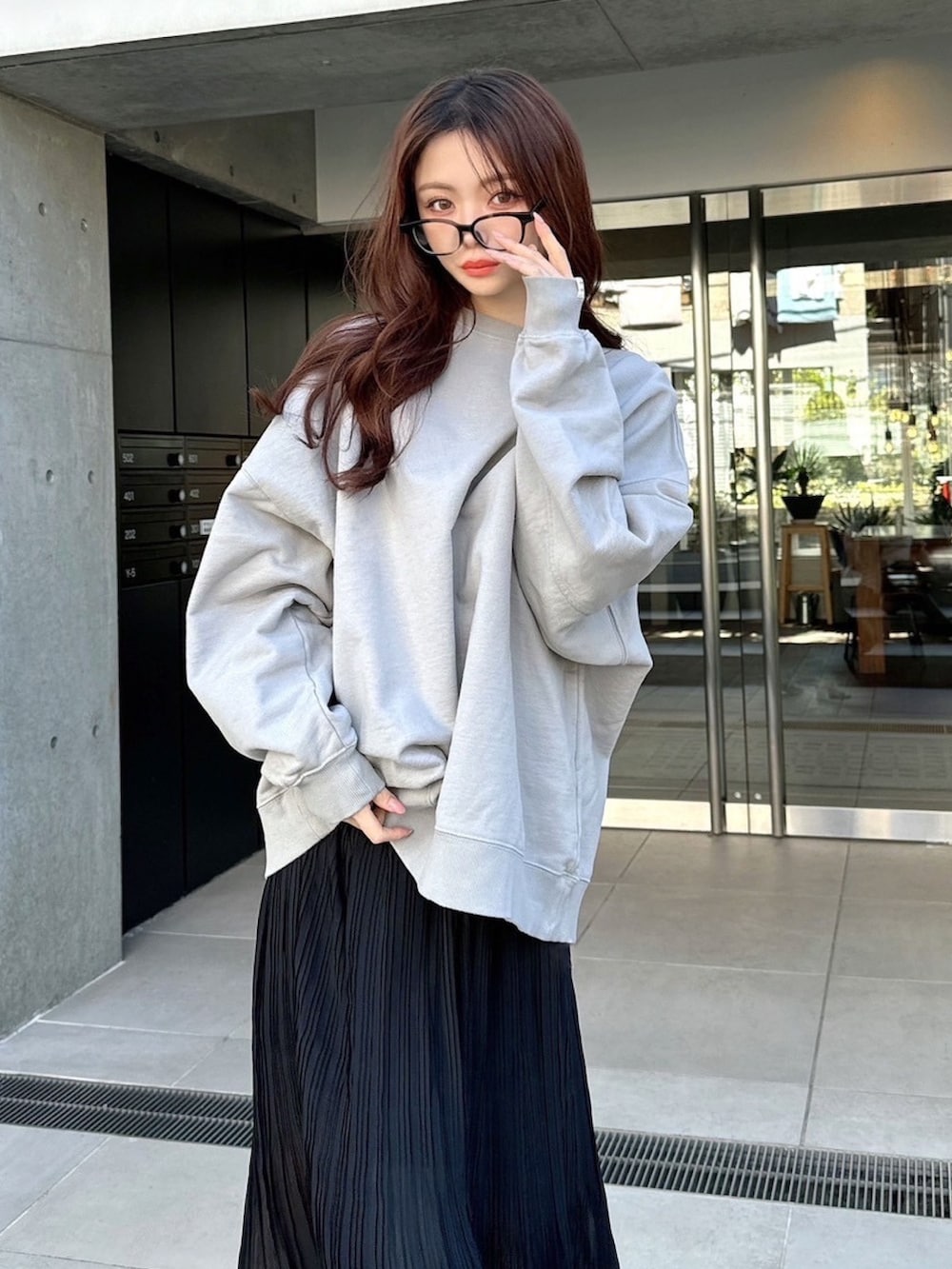 グレー系のスウェット、ブラック系のスカートを着用したレディースの春コーディネートの3枚目の写真