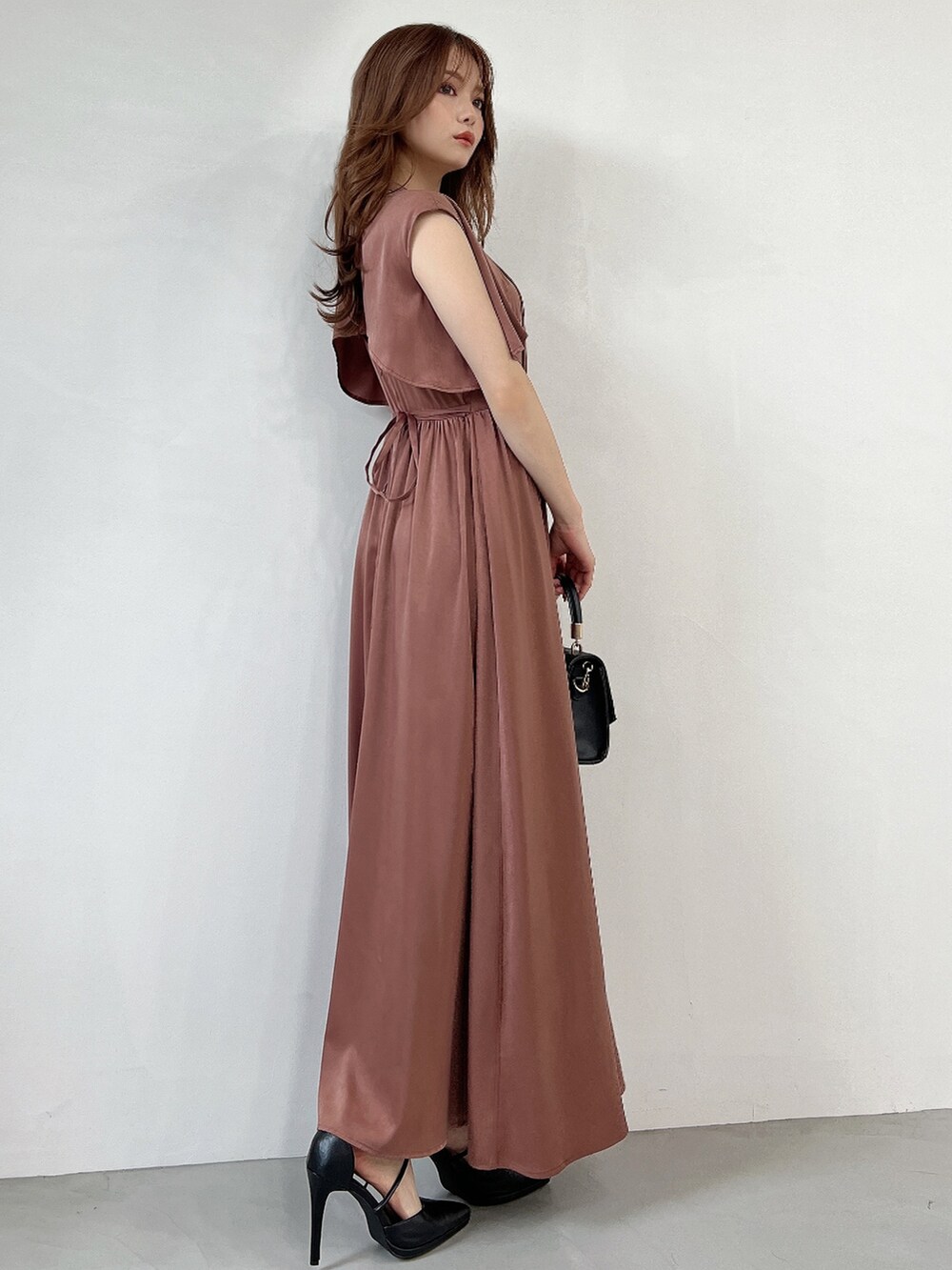 ブラウン系のドレス、ブラック系のパンプスを着用したレディースの秋コーディネートの2枚目の写真