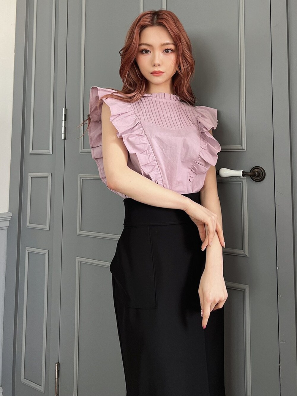 ブラック系のサンダル、ブラック系のスカート、ピンク系のシャツ/ブラウスを着用したレディースの春コーディネートの2枚目の写真