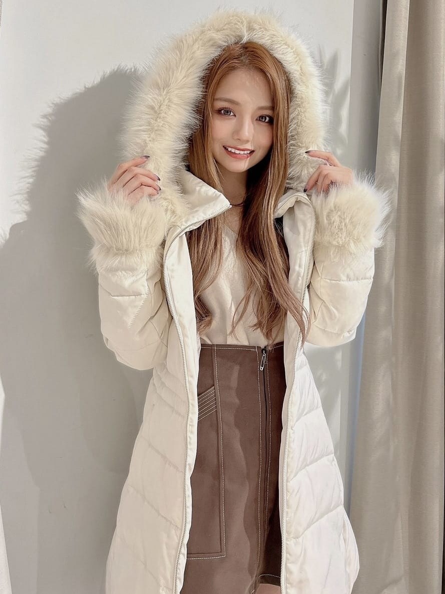 ベージュ系のニット/セーター、ホワイト系のダウンジャケット/コート、ブラウン系のブーツを着用したレディースの秋コーディネートの2枚目の写真