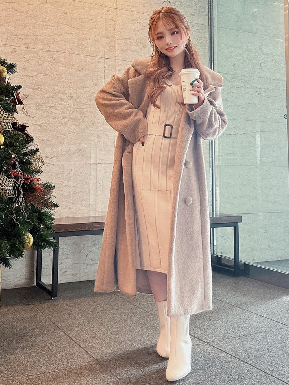 ホワイト系のブーツ、ベージュ系のその他アウター、ベージュ系のワンピースを着用したレディースの冬コーディネートの3枚目の写真