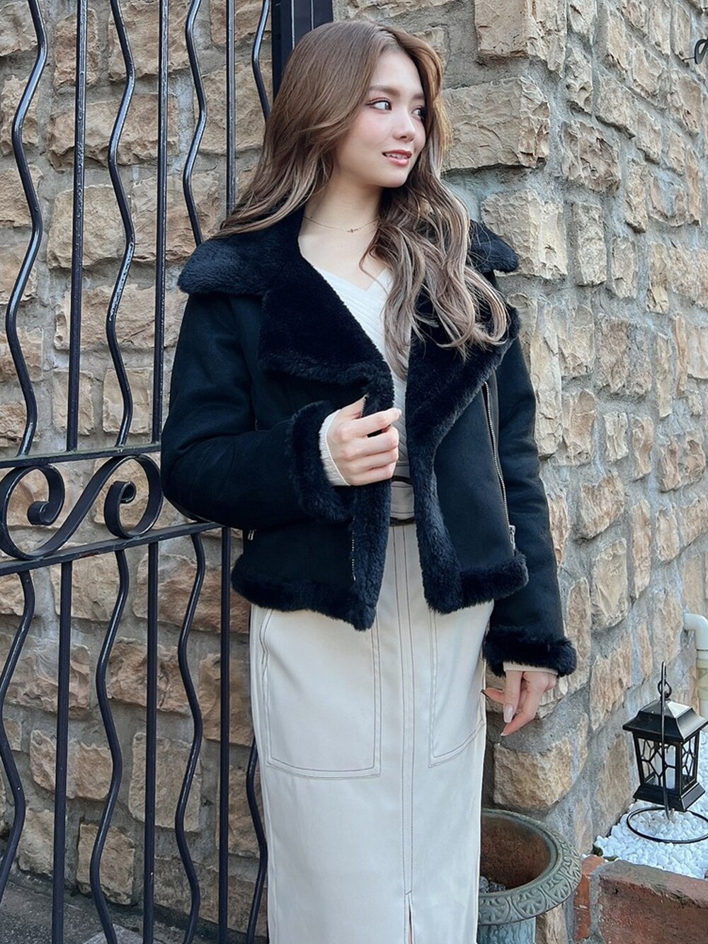 ホワイト系のスカート、ブラック系のブルゾン、ブラック系のブーツを着用したレディースの冬コーディネートの4枚目の写真