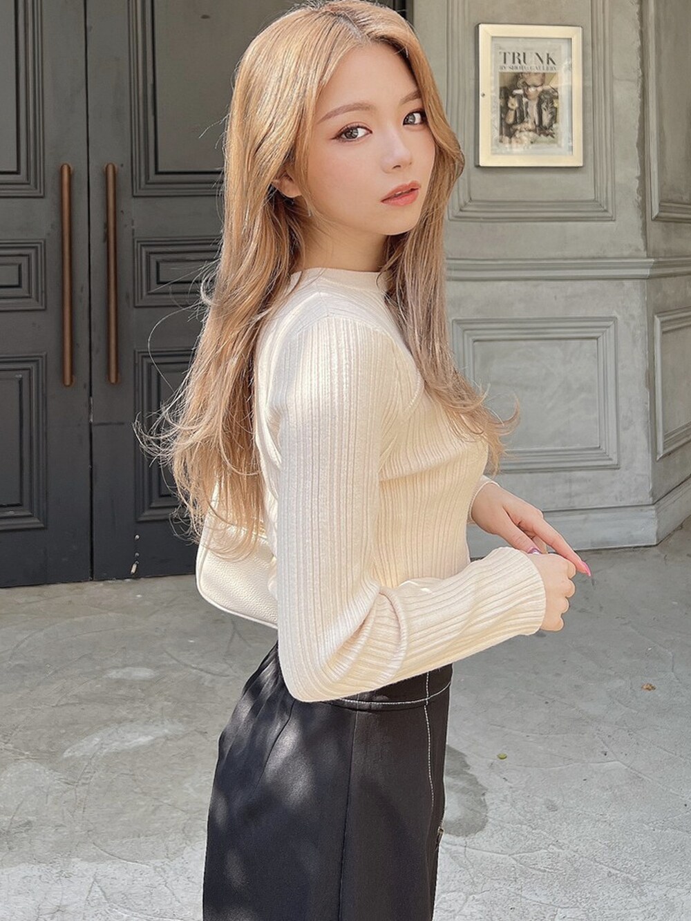 ブラック系のその他パンツ、ホワイト系のニット/セーター、ブラウン系のブーツを着用したレディースの春コーディネートの2枚目の写真