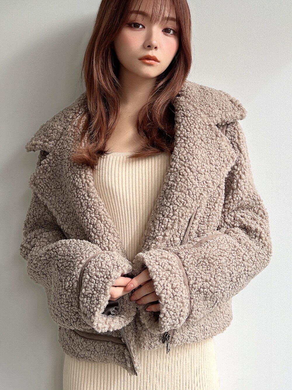 ブラウン系のブルゾン、ホワイト系のワンピース、ブラウン系のブーツを着用したレディースの秋コーディネートの3枚目の写真