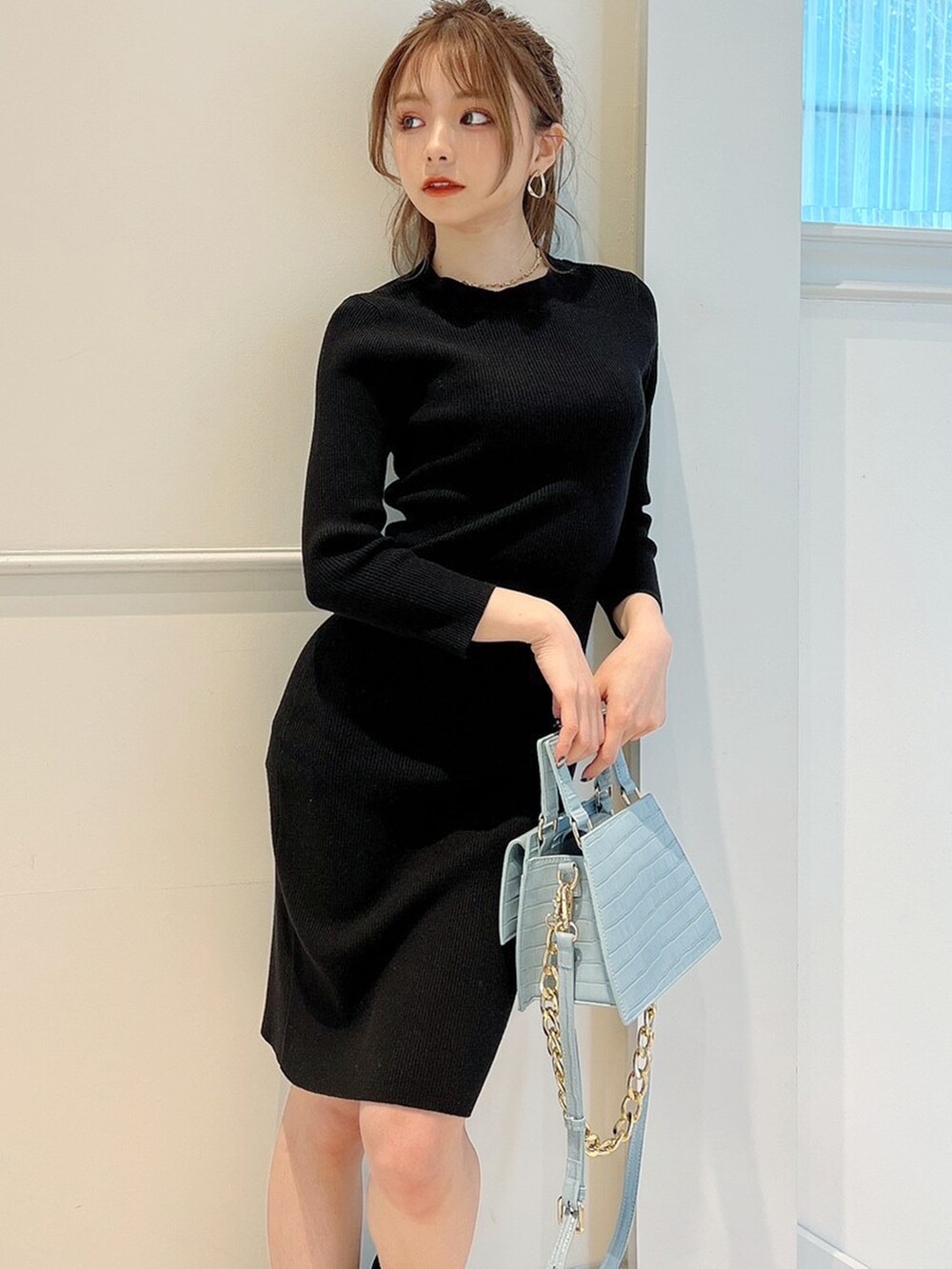 ブラック系のワンピース、ブラック系のブーツ、ブルー系のショルダーバッグを着用したレディースの冬コーディネートの2枚目の写真