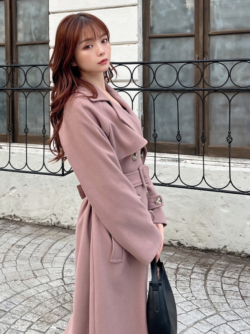 ピンク系のその他アウター、ブラック系のワンピース、ブラック系のハンドバッグを着用したレディースの冬コーディネートの3枚目の写真