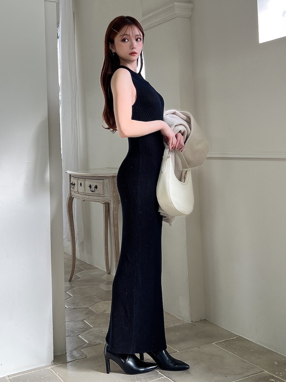 その他のワンピース、ホワイト系のハンドバッグ、ブラック系のブーツを着用したレディースの冬コーディネートの7枚目の写真