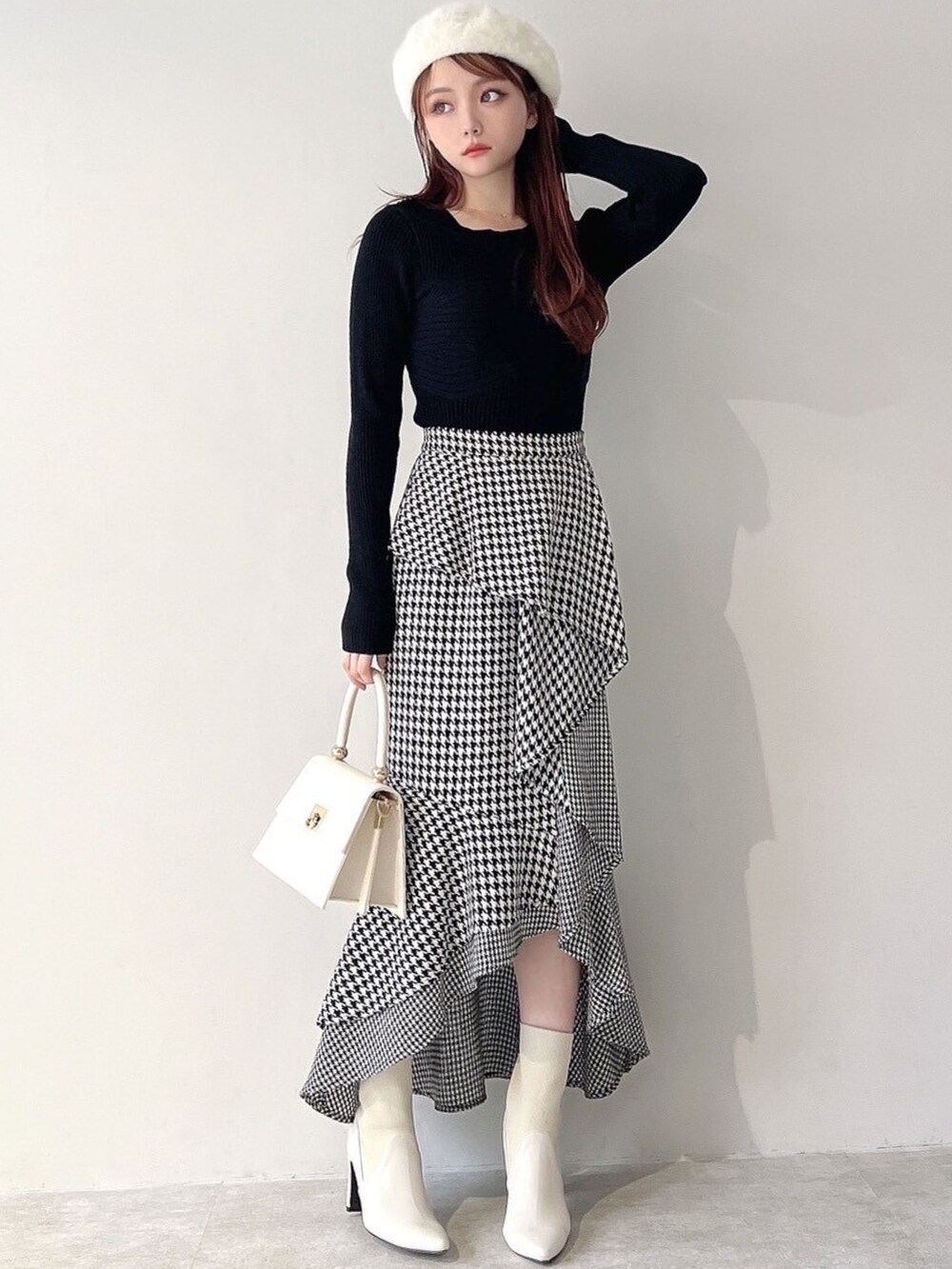 ホワイト系のチェスターコート、ホワイト系のハンドバッグ、ホワイト系のブーツを着用したレディースの秋コーディネートの8枚目の写真