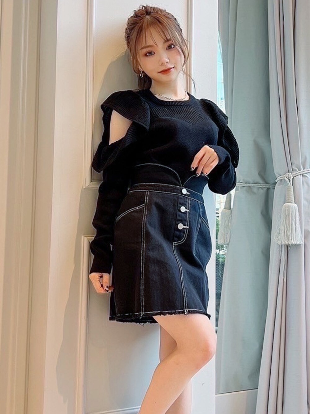 ブラック系のスカート、ブラック系のニット/セーターを着用したレディースの春コーディネートの3枚目の写真