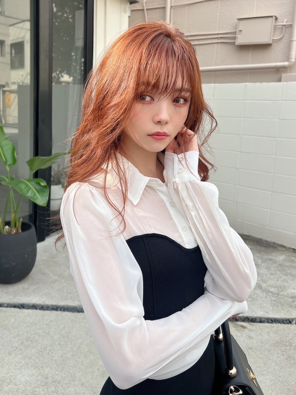 ブラック系のワンピース、ブラック系のハンドバッグ、ブラック系のブーツを着用したレディースの秋コーディネートの5枚目の写真