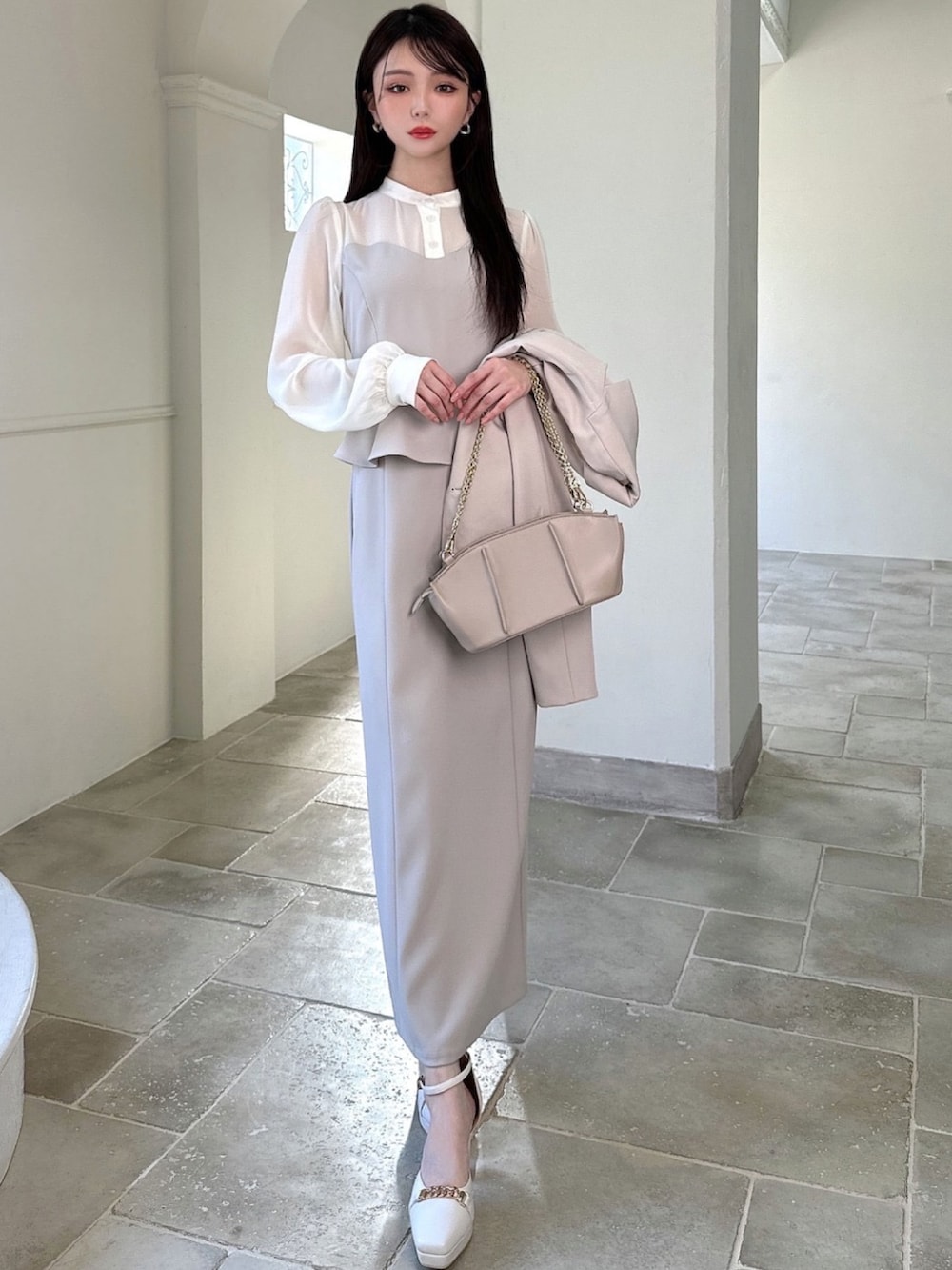 ベージュ系のワンピース、ベージュ系のテーラードジャケット、ベージュ系のハンドバッグを着用したレディースの冬コーディネートの3枚目の写真