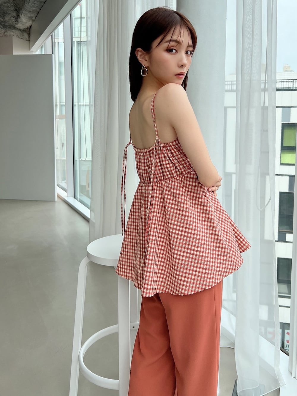 オレンジ系のキャミソール、オレンジ系のその他パンツ、ホワイト系のハンドバッグを着用したレディースの春コーディネートの3枚目の写真