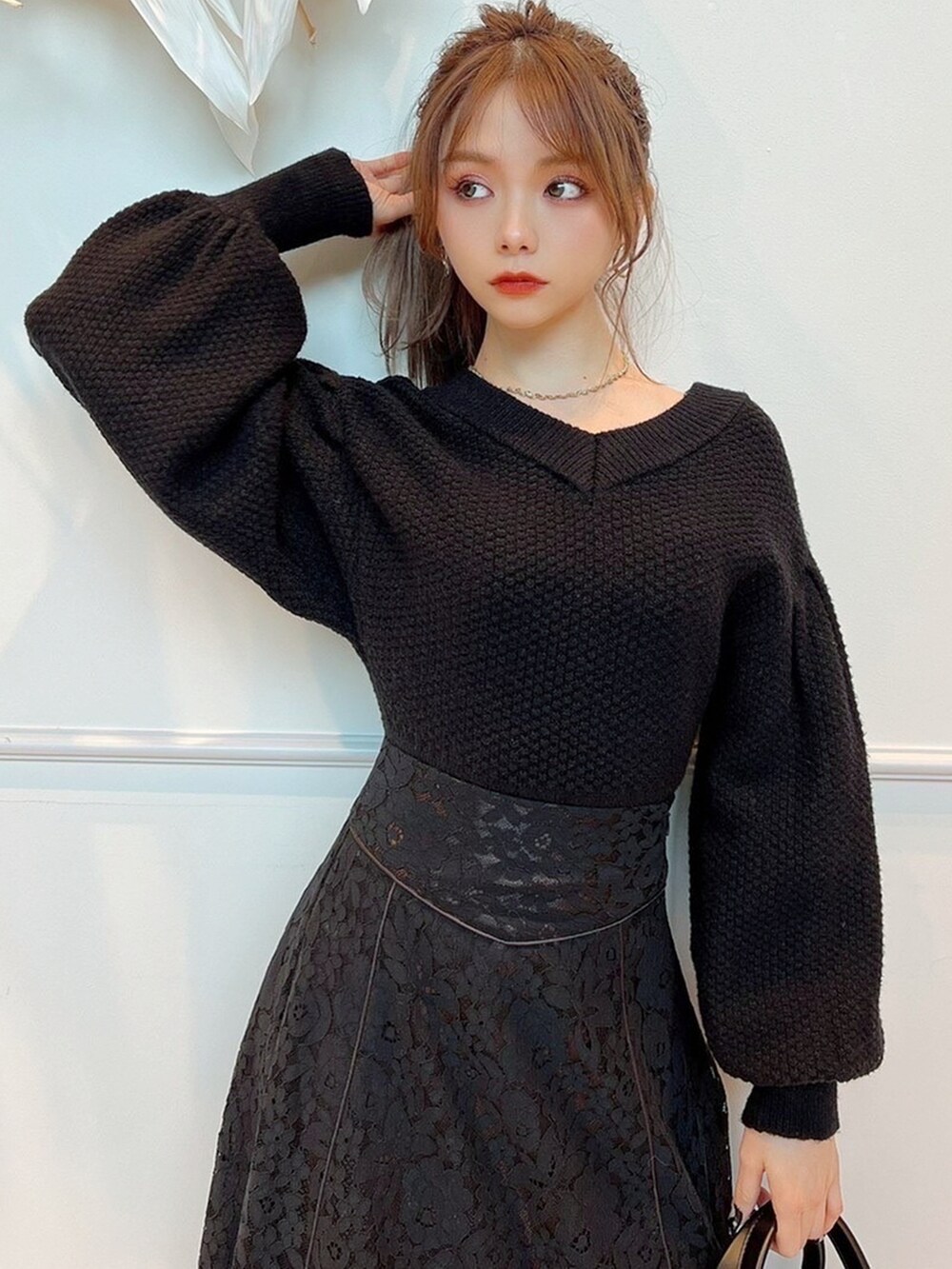 ブラック系のスカート、ブラック系のブーツ、ブラック系のニット/セーターを着用したレディースの冬コーディネートの3枚目の写真