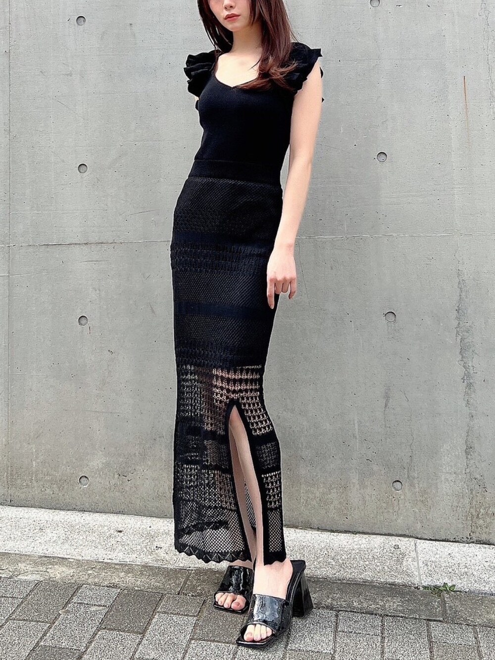 ブラック系のワンピース、ブラック系のサンダルを着用したレディースの春コーディネートの2枚目の写真