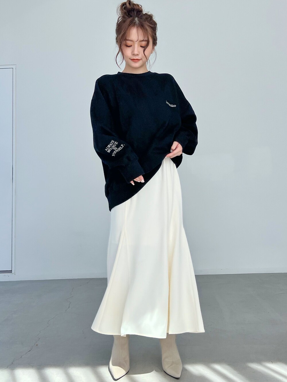 ホワイト系のブーツ、ホワイト系のスカートを着用したレディースの秋コーディネートの4枚目の写真