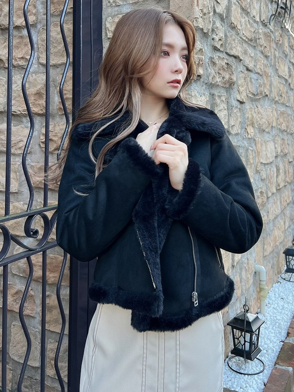 ホワイト系のスカート、ブラック系のブルゾン、ブラック系のブーツを着用したレディースの冬コーディネートの3枚目の写真