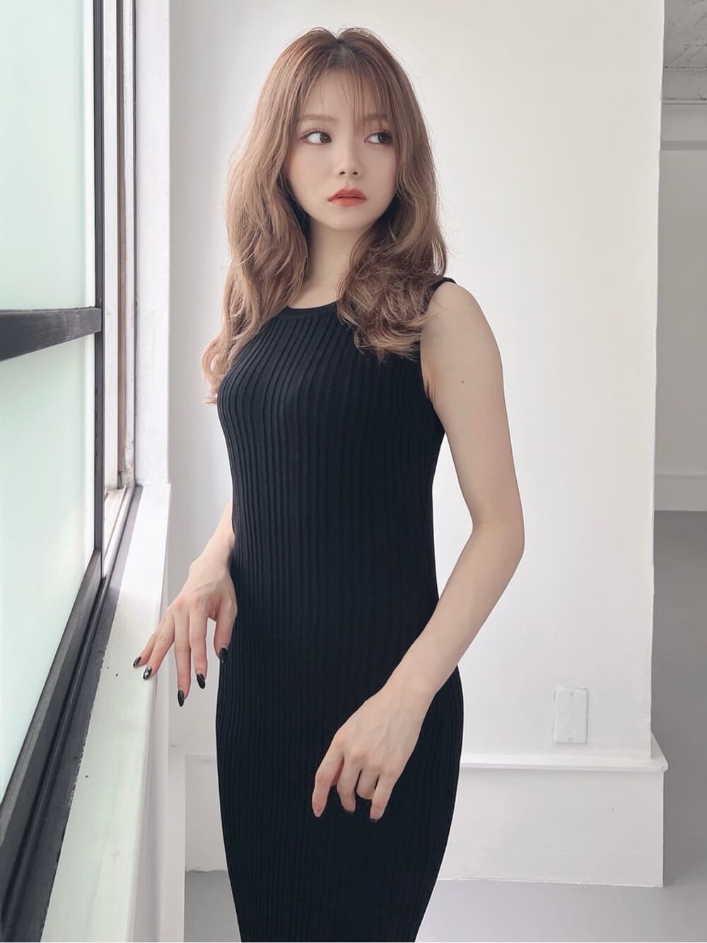 ブラック系のワンピース、ベージュ系のサンダルを着用したレディースの夏コーディネートの4枚目の写真