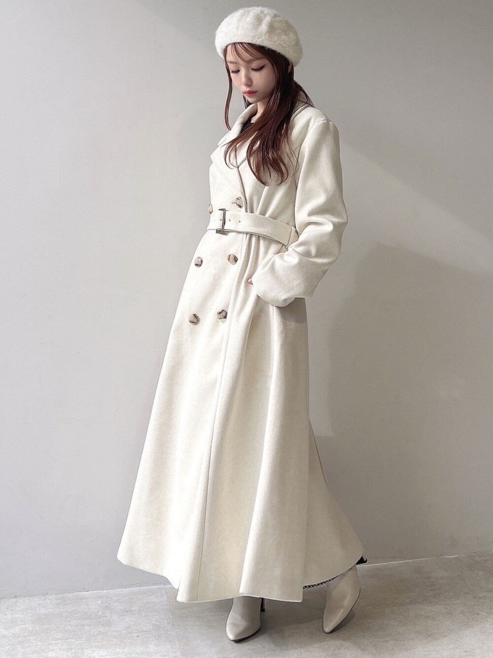 ホワイト系のチェスターコート、ホワイト系のハンドバッグ、ホワイト系のブーツを着用したレディースの秋コーディネートの5枚目の写真