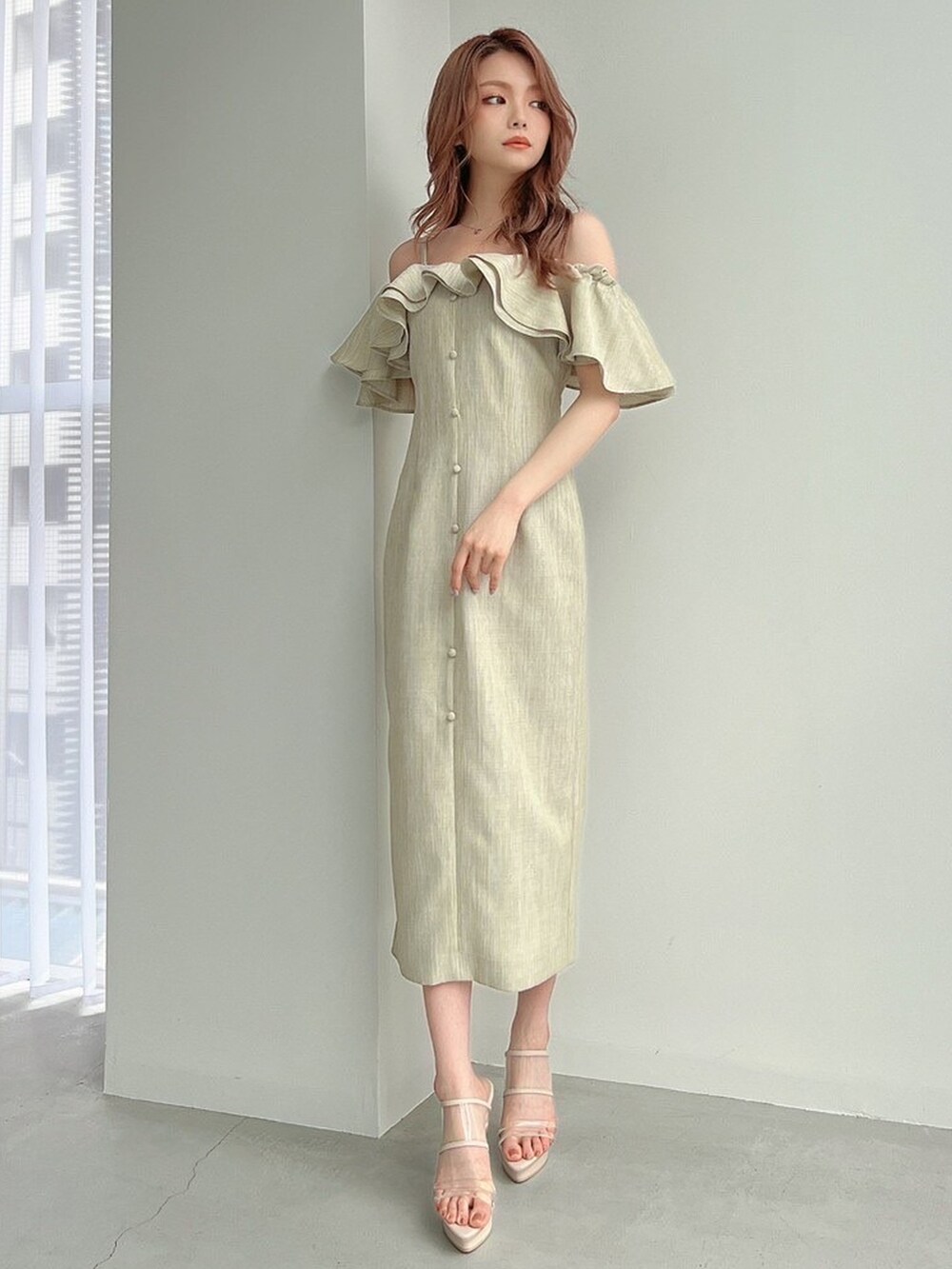 ホワイト系のサンダル、グリーン系のワンピースを着用したレディースの春コーディネートの2枚目の写真