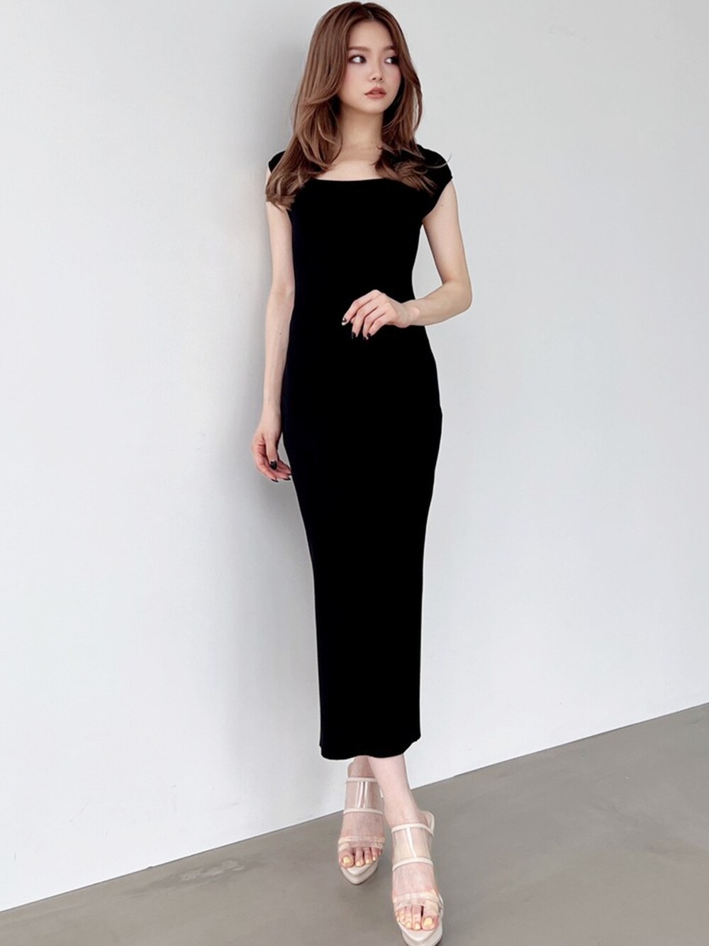 ベージュ系のサンダル、ブラック系のワンピースを着用したレディースの夏コーディネートの3枚目の写真