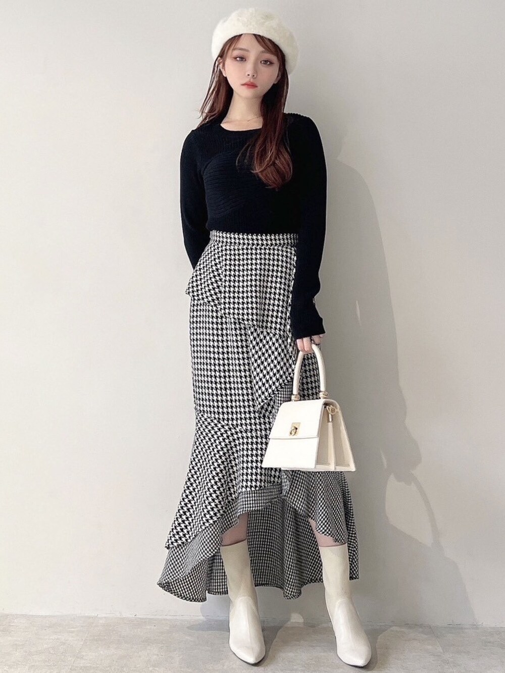 ホワイト系のチェスターコート、ホワイト系のハンドバッグ、ホワイト系のブーツを着用したレディースの秋コーディネートの9枚目の写真