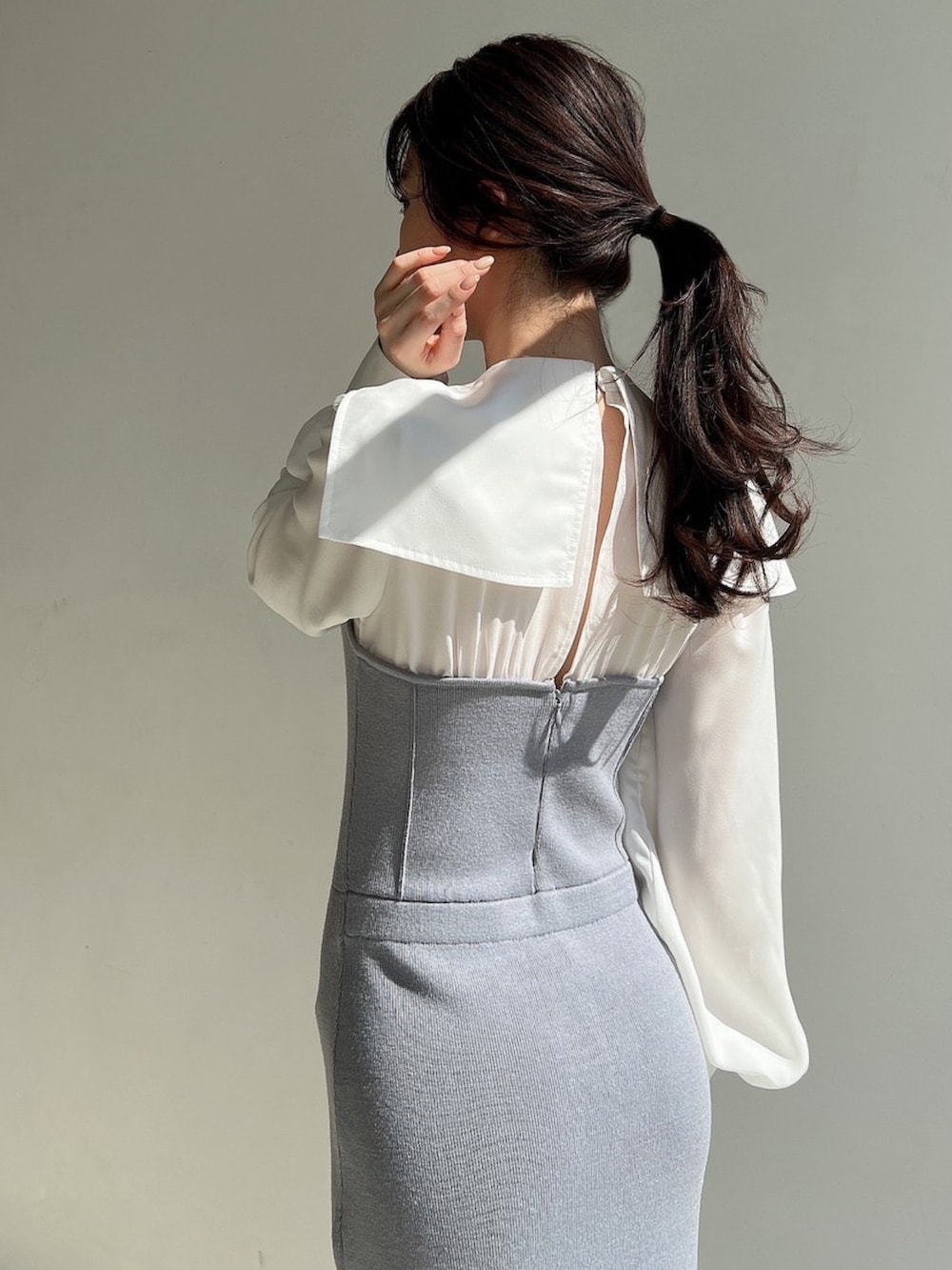 ブルー系のワンピース、ホワイト系のトレンチコートを着用したレディースの冬コーディネートの4枚目の写真