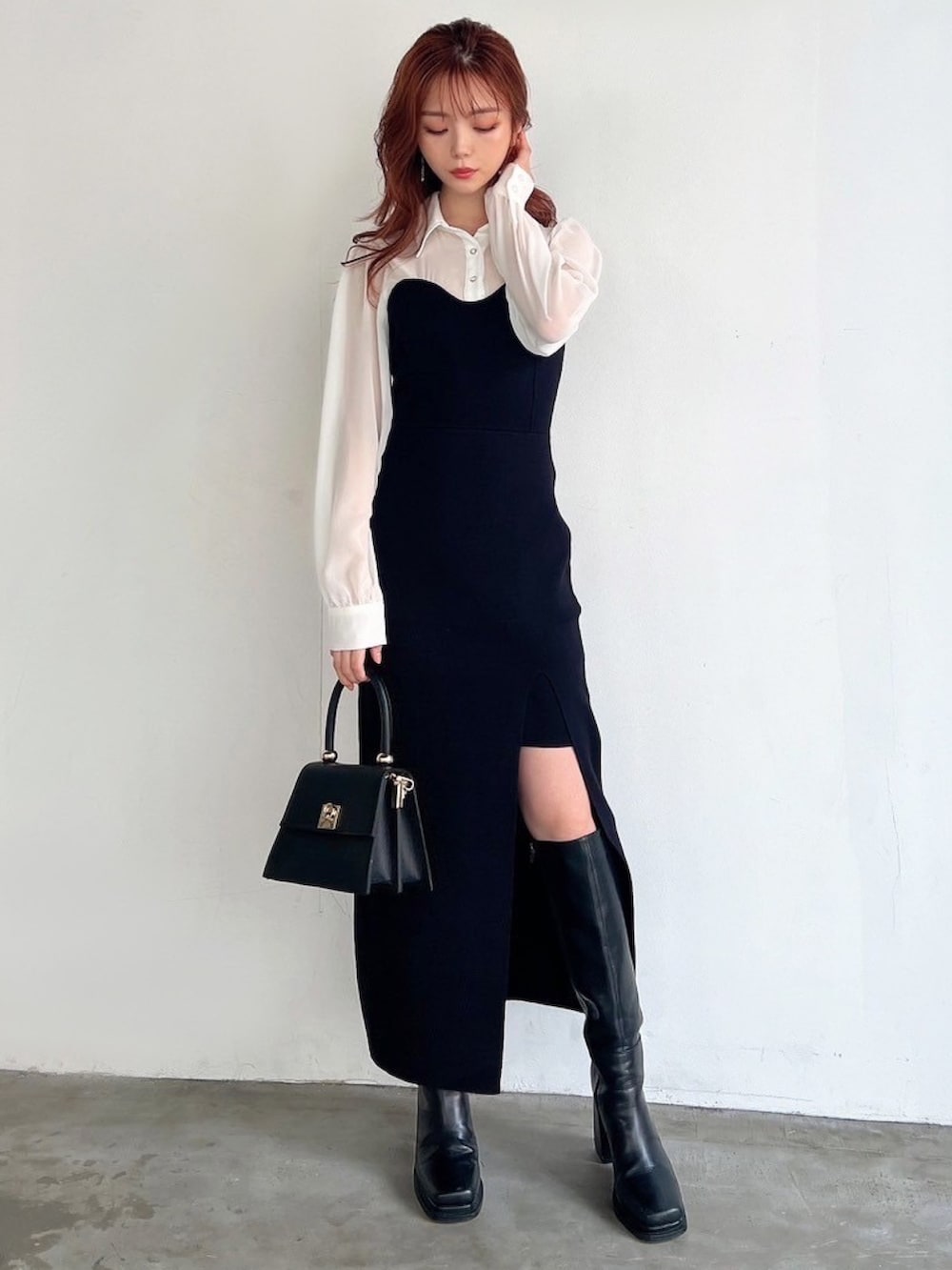 ブラック系のワンピース、ブラック系のハンドバッグ、ブラック系のブーツを着用したレディースの秋コーディネートの3枚目の写真