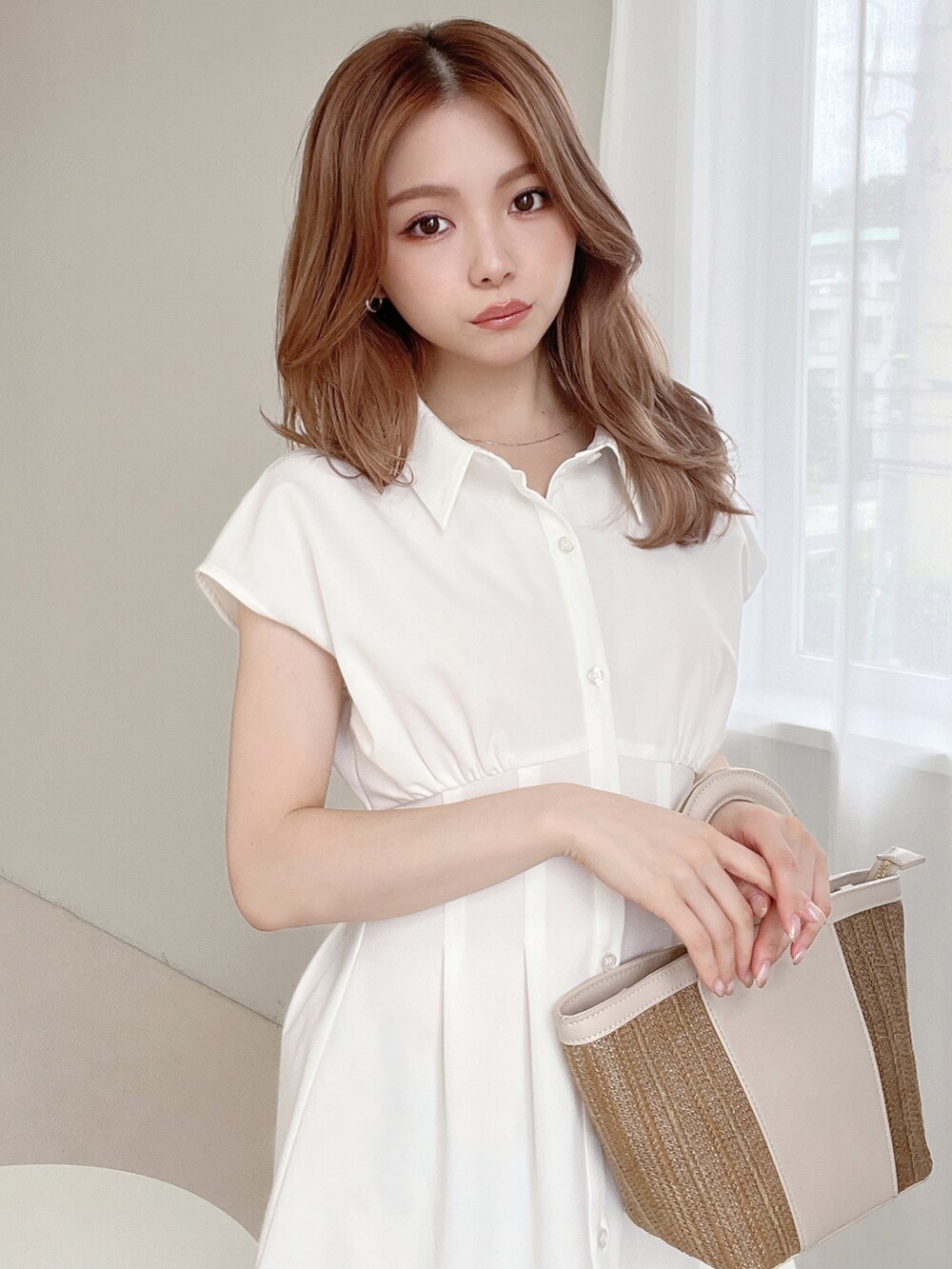 ホワイト系のワンピース、ベージュ系のサンダル、ベージュ系のハンドバッグを着用したレディースの夏コーディネートの3枚目の写真