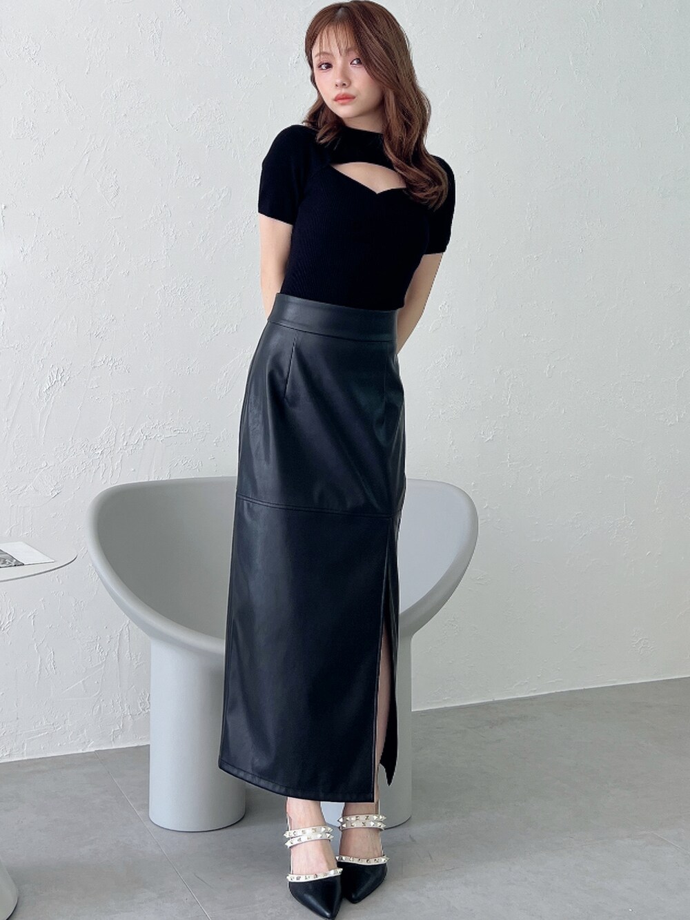 ブラック系のスカート、ブラック系のパンプス、ブラック系のニット/セーターを着用したレディースの夏コーディネートの2枚目の写真