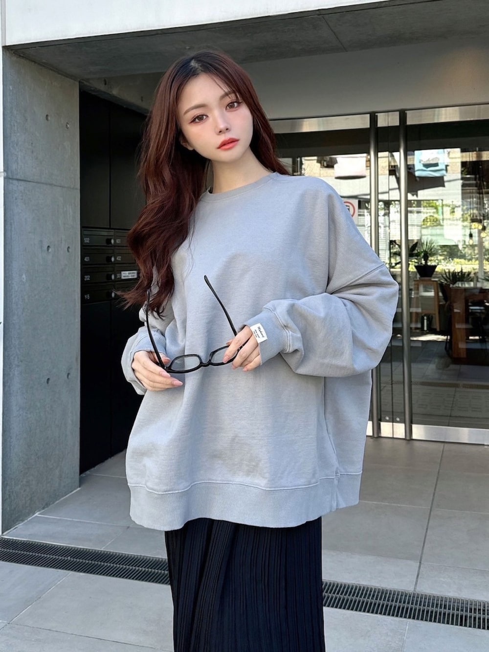 グレー系のスウェット、ブラック系のスカートを着用したレディースの春コーディネートの4枚目の写真