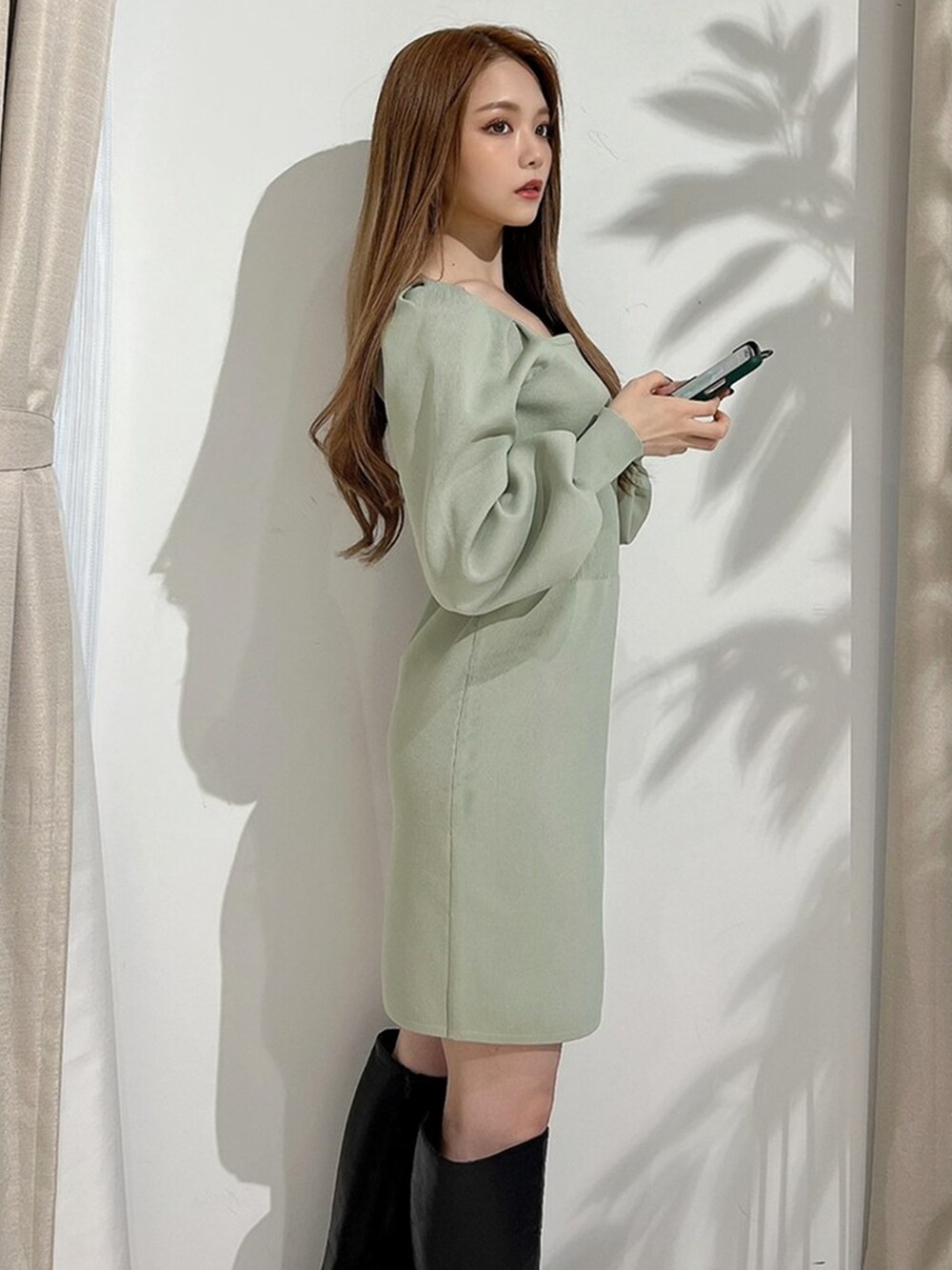 ブラック系のブーツ、グリーン系のワンピースを着用したレディースの冬コーディネートの3枚目の写真