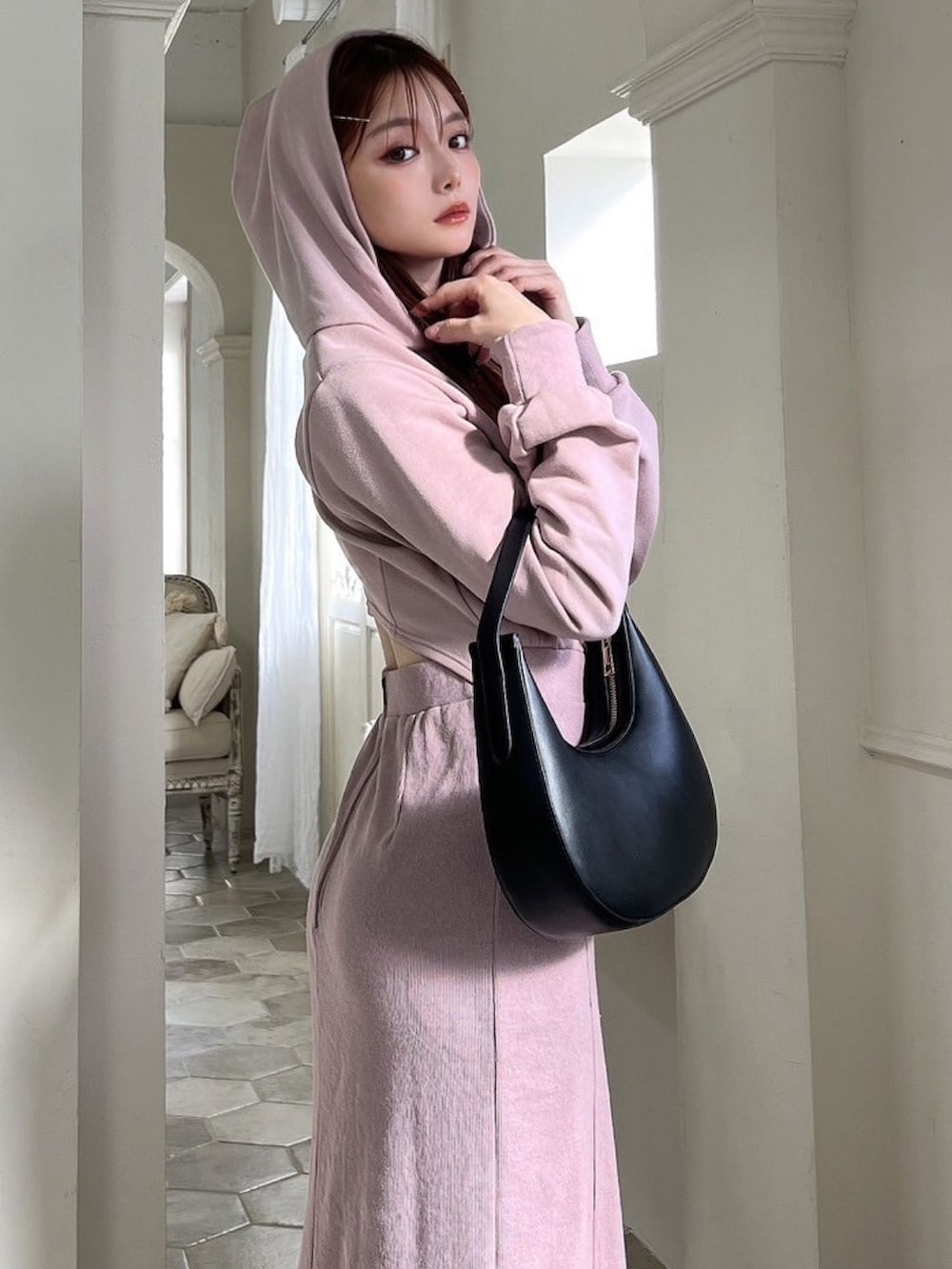 ピンク系のワンピース、ブラック系のハンドバッグ、ブラック系のブーツを着用したレディースの冬コーディネートの4枚目の写真