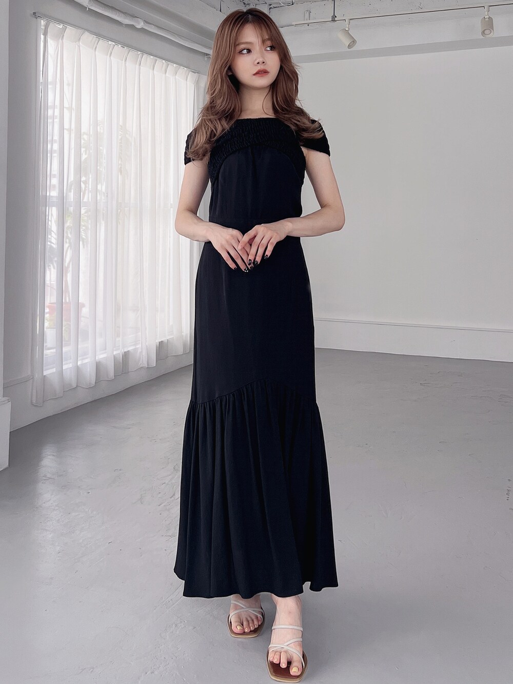 ベージュ系のサンダル、ブラック系のワンピースを着用したレディースの夏コーディネートの2枚目の写真