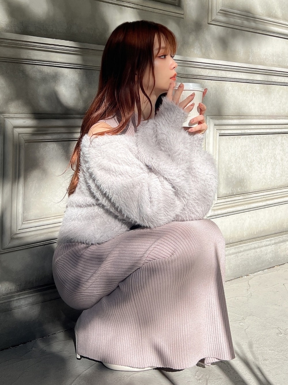 グレー系のワンピース、ホワイト系のブーツを着用したレディースの冬コーディネートの2枚目の写真