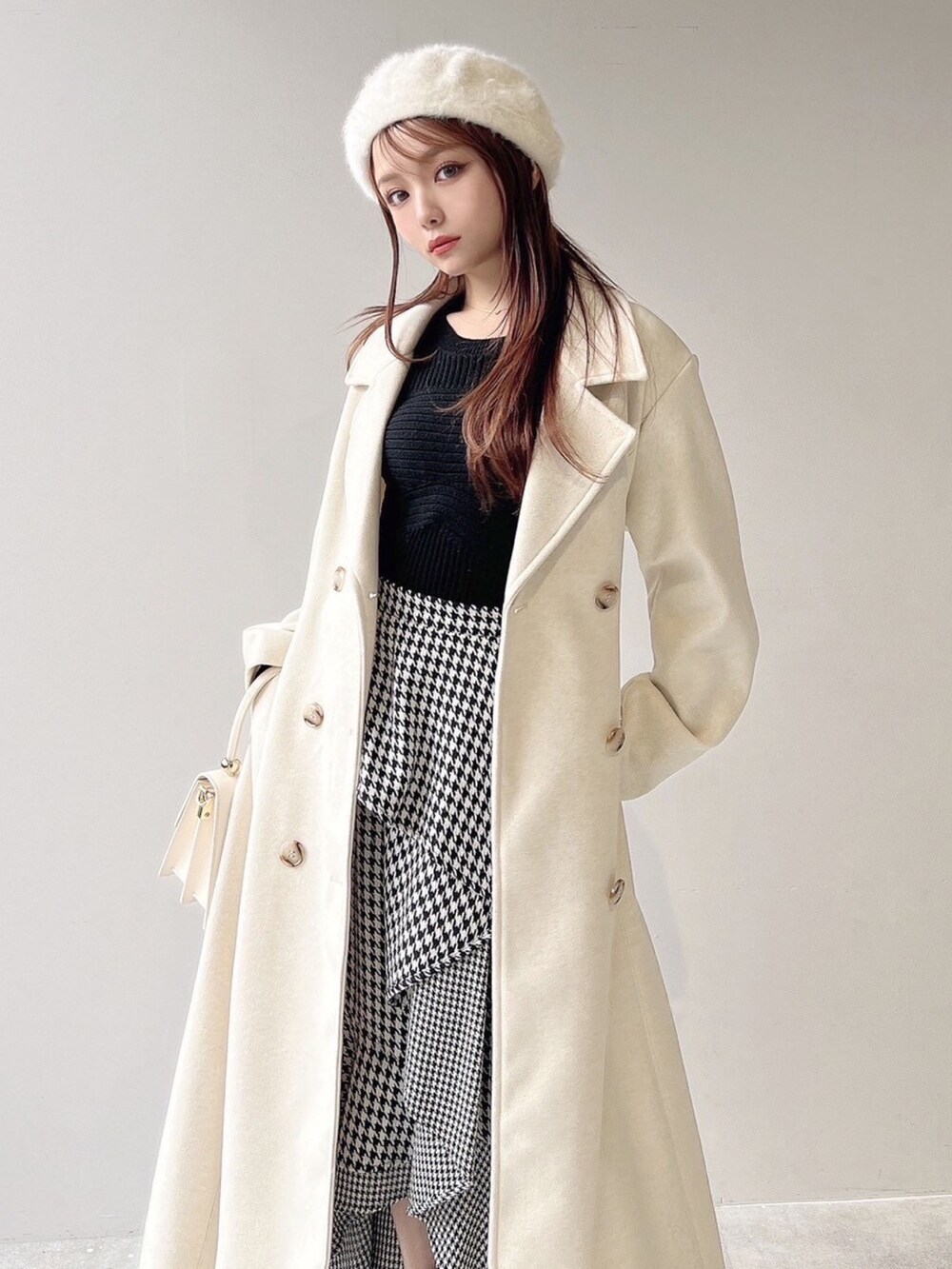 ホワイト系のチェスターコート、ホワイト系のハンドバッグ、ホワイト系のブーツを着用したレディースの秋コーディネートの6枚目の写真